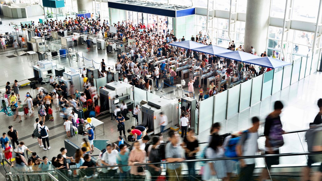 people going through security at a crowded airport